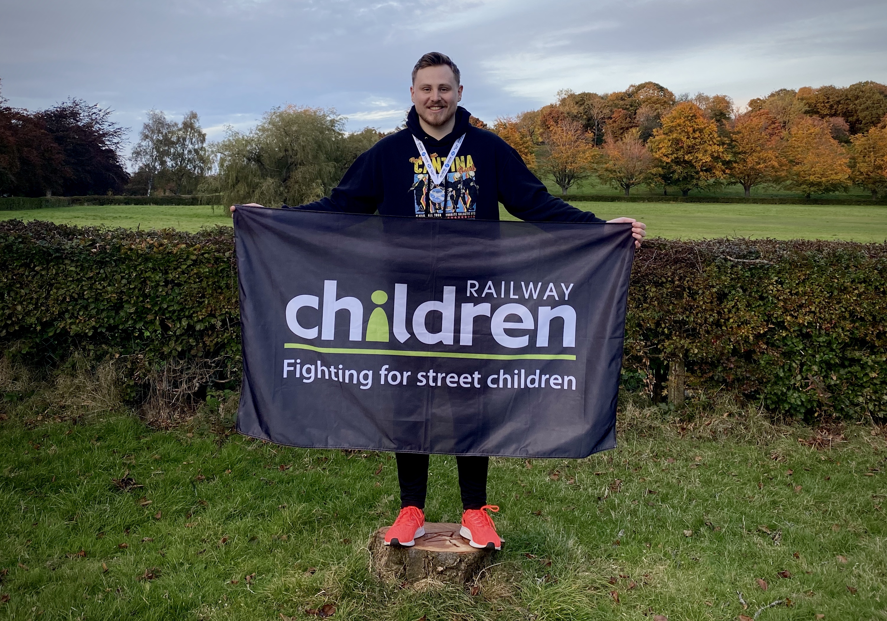 Martyn Ross holding a Railway Children brandedflag
